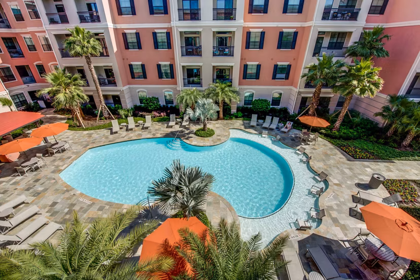 Luxurious pool area with lounging chairs at Grove at Wilcrest Apartments