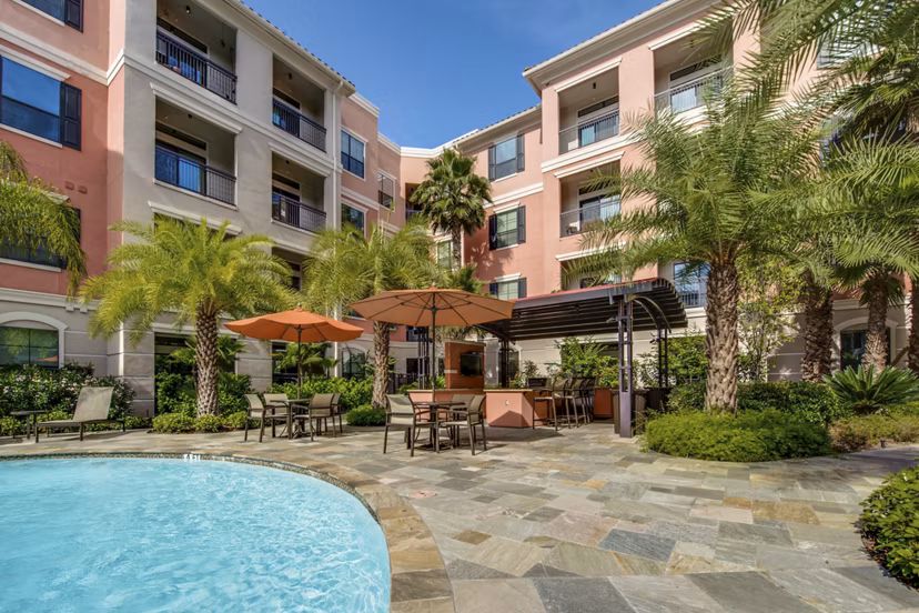 Resort-style pool area with lounge chairs at Grove at Wilcrest Apartments, offering luxury living spaces and amenities in Houston