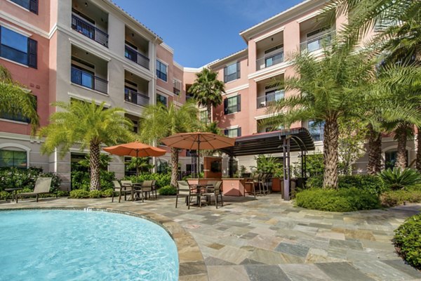 Resort-style pool area with lounge chairs at Grove at Wilcrest Apartments, offering luxury living spaces and amenities in Houston