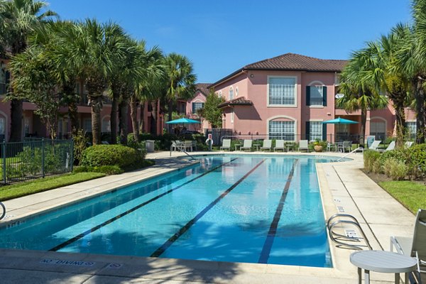 Resort-style pool with palm trees at Las Palmas Apartments, offering luxury outdoor relaxation spaces for residents
