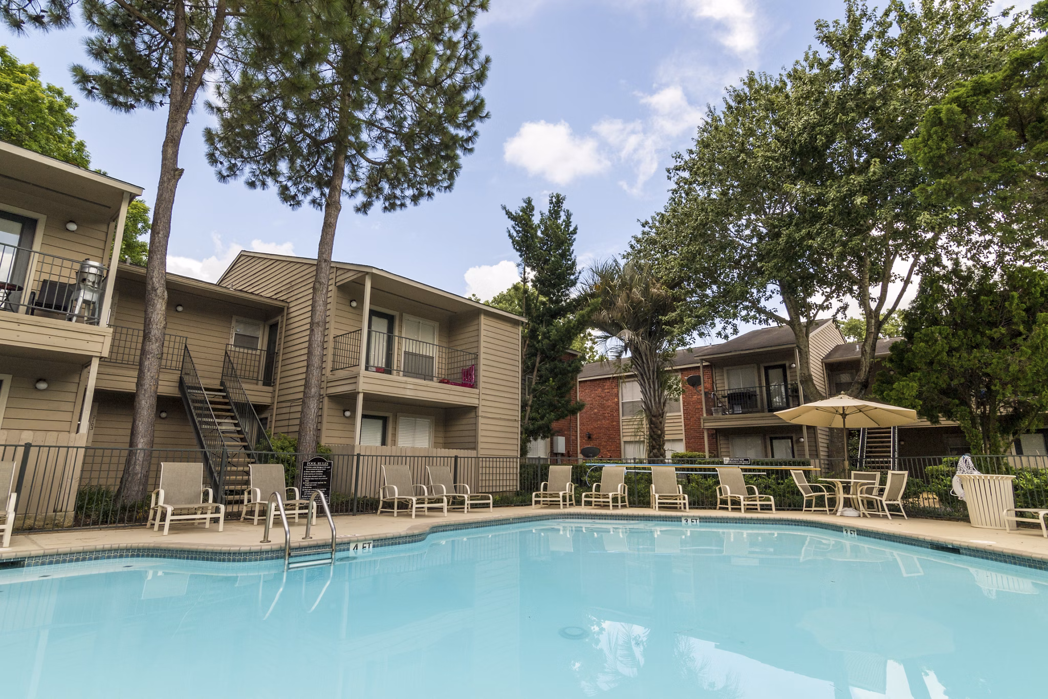 Outdoor pool with lounge chairs at Sabo Village Apartments, a luxury living community offering resort-style amenities
