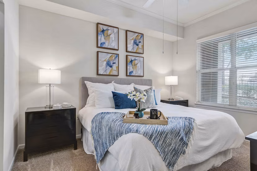 Kingsboro Luxury Apartments: Elegant bedroom with cozy decor and large windows offering natural light