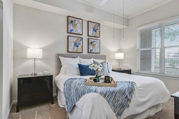 Kingsboro Luxury Apartments: Elegant bedroom with cozy decor and large windows offering natural light
