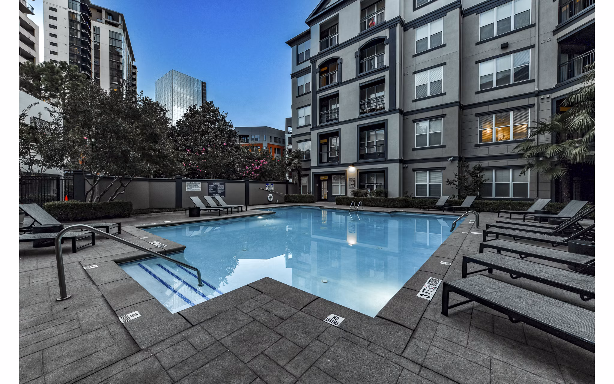 Luxurious outdoor pool at Kingsboro Luxury Apartments with lounge seating and scenic views, perfect for relaxation and leisure activities