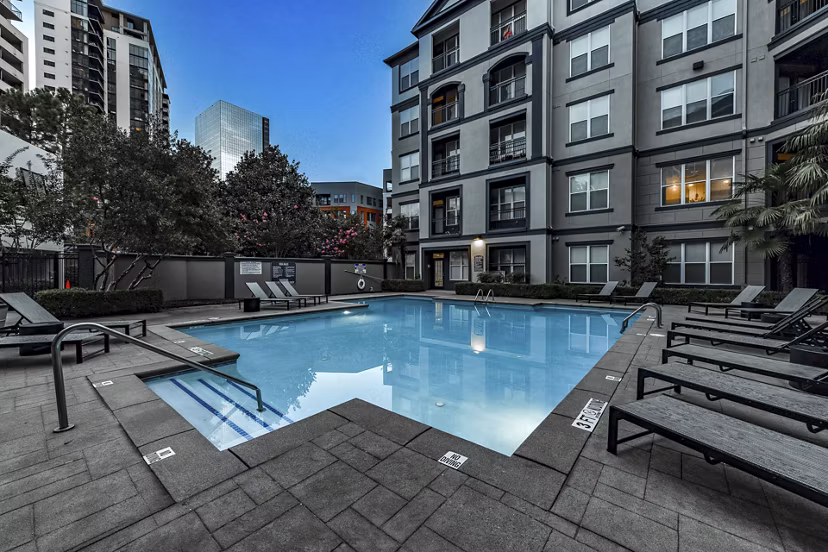 Luxurious outdoor pool at Kingsboro Luxury Apartments with lounge seating and scenic views, perfect for relaxation and leisure activities