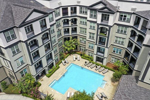 Luxurious swimming pool with lounge chairs at Kingsboro Luxury Apartments, ideal for relaxation and leisure