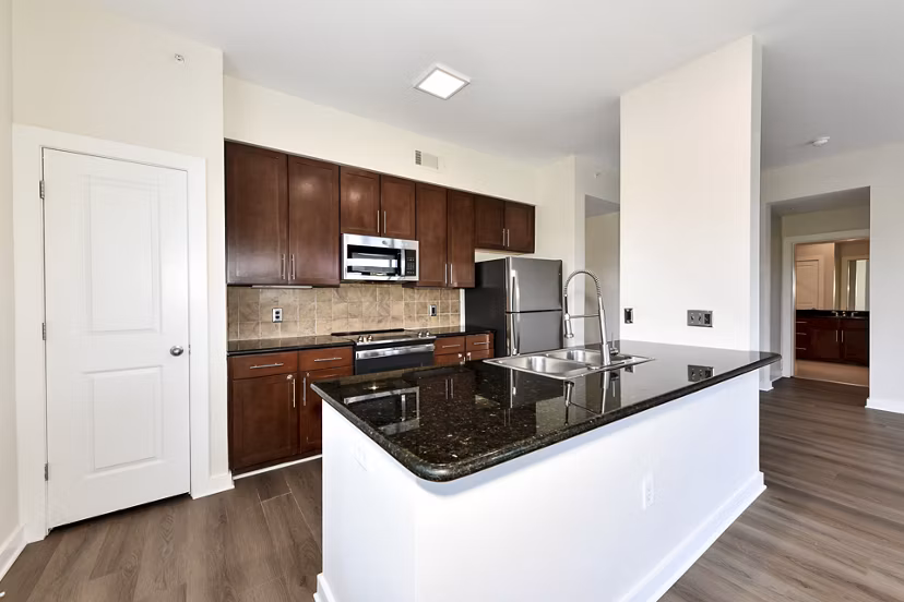 Kitchen featuring modern appliances and granite countertops in Peachtree Dunwoody Place Apartments