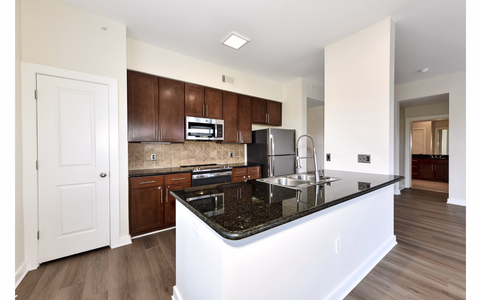 Kitchen featuring modern appliances and granite countertops in Peachtree Dunwoody Place Apartments