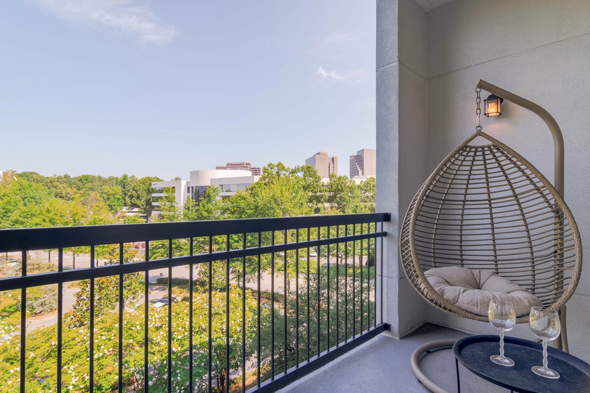 Patio with comfortable seating and lush greenery at Peachtree Dunwoody Place Apartments, a luxury living community in Atlanta