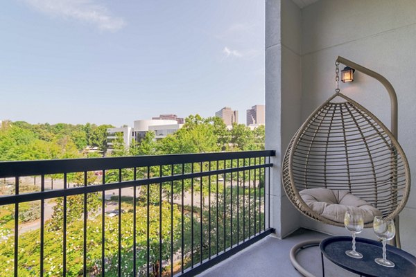 Patio with comfortable seating and lush greenery at Peachtree Dunwoody Place Apartments, a luxury living community in Atlanta
