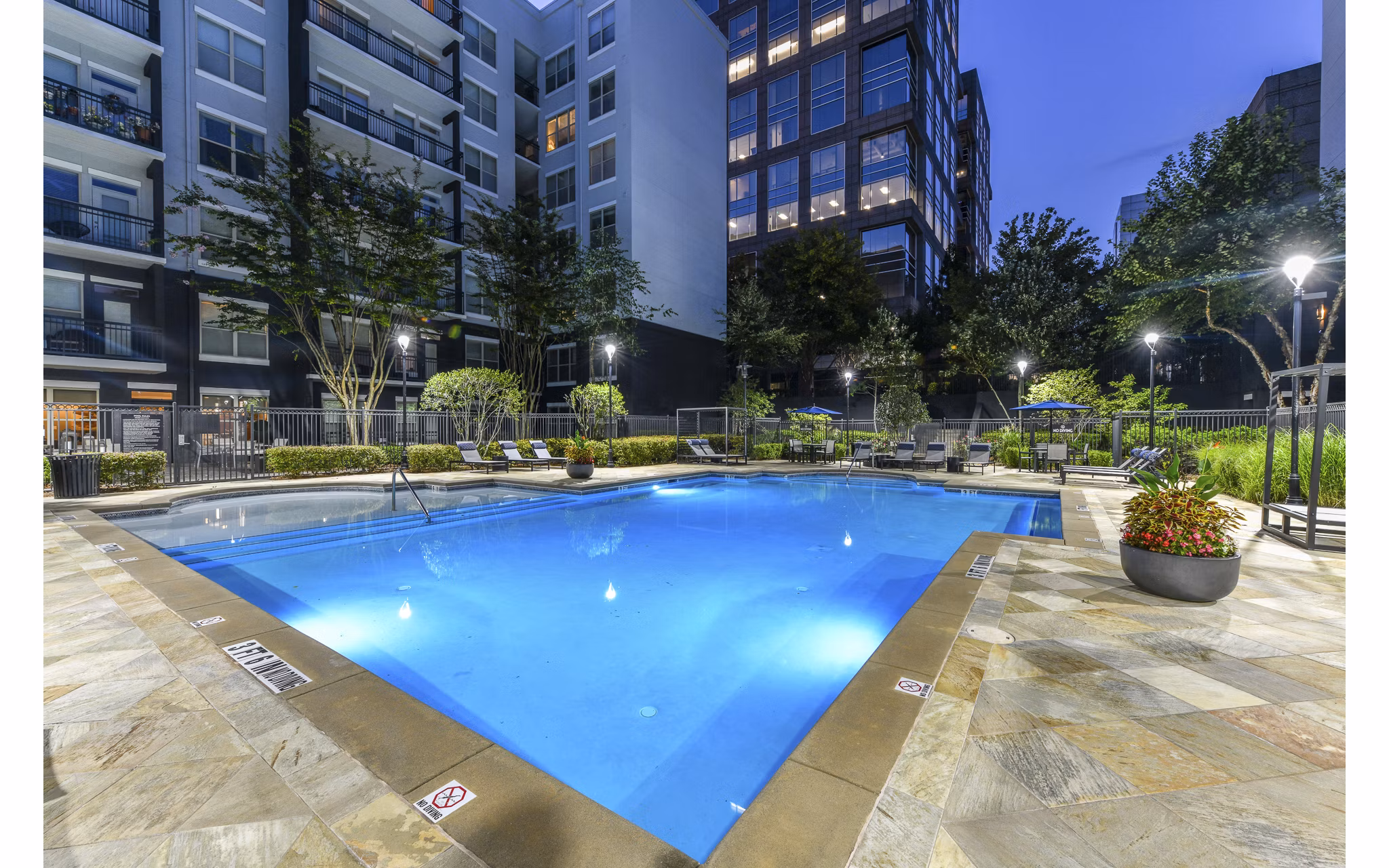 Outdoor pool at Peachtree Dunwoody Place Apartments with sundeck and lounge chairs, offering a relaxing space for residents