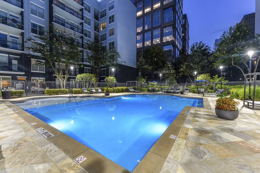 Outdoor pool at Peachtree Dunwoody Place Apartments with sundeck and lounge chairs, offering a relaxing space for residents