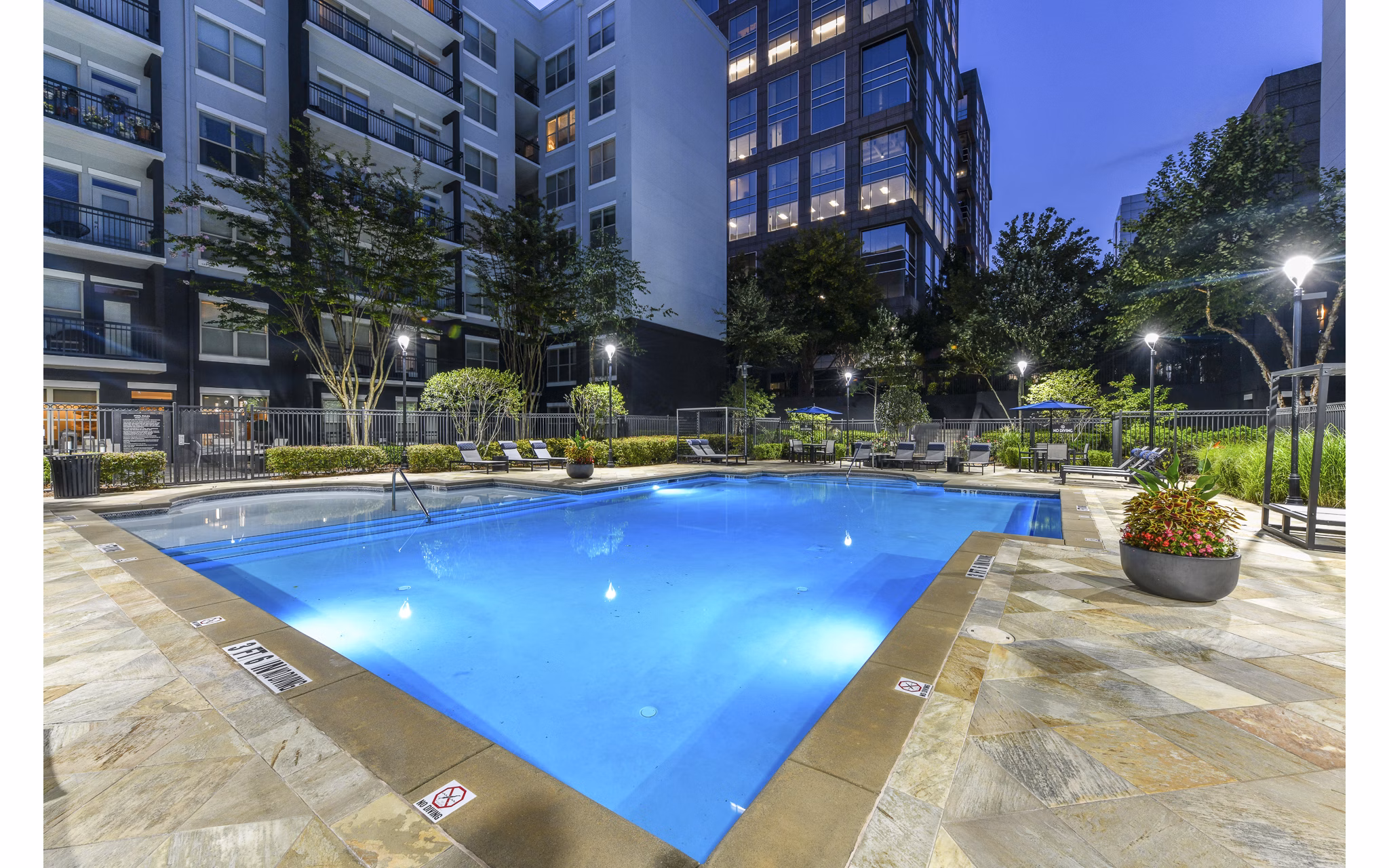 Outdoor pool at Peachtree Dunwoody Place Apartments with sundeck and lounge chairs, offering a relaxing space for residents