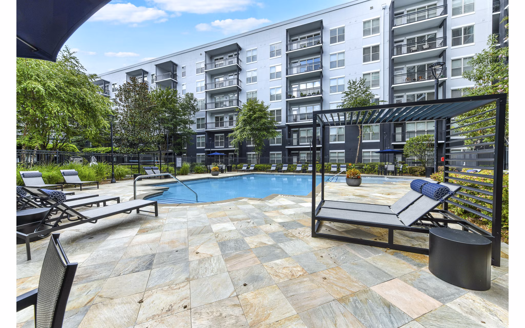 Modern pool with palm trees at Peachtree Dunwoody Place Apartments, offering luxury amenities in Atlanta's Greystar community