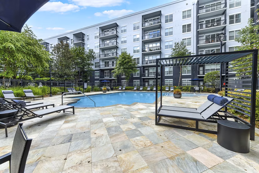 Modern pool with palm trees at Peachtree Dunwoody Place Apartments, offering luxury amenities in Atlanta's Greystar community