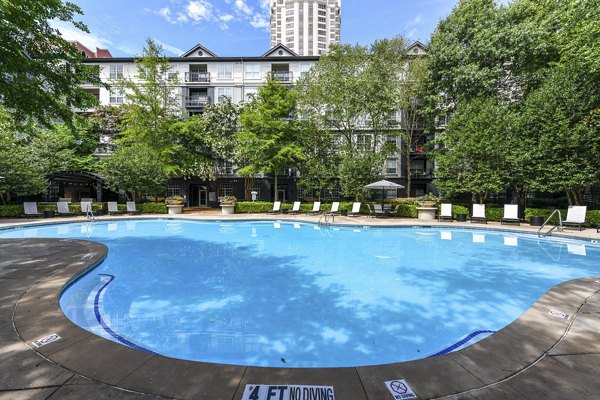 Elegant outdoor pool at Phipps Place Apartments with sun loungers and lush greenery, offering a relaxing retreat for residents