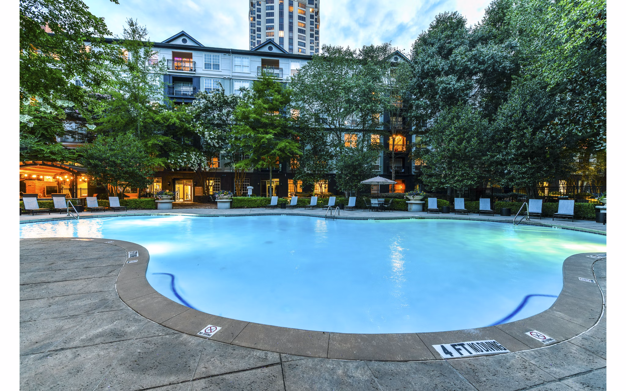 Luxurious pool at Phipps Place Apartments with sun loungers and lush landscaping