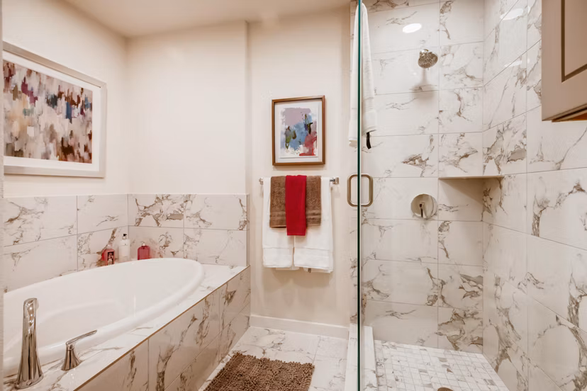 Bathroom with modern fixtures and lighted mirror at The Caroline Apartments