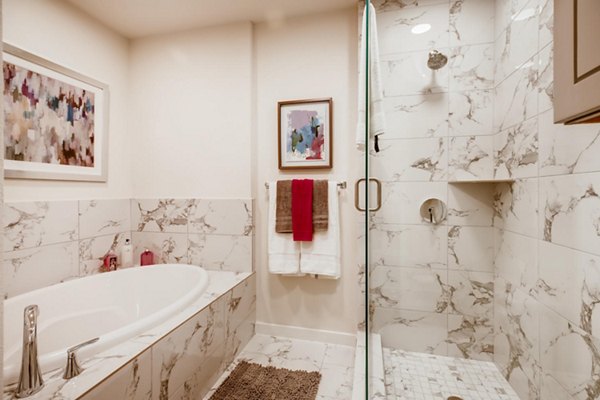 Bathroom with modern fixtures and lighted mirror at The Caroline Apartments