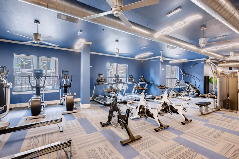 Fully-equipped fitness center with modern machines at The Caroline Apartments