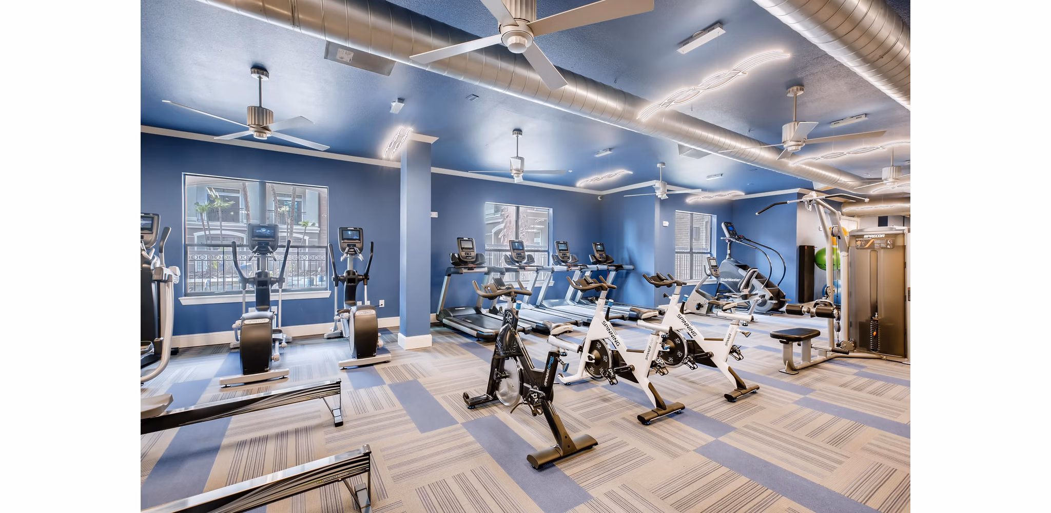 Fully-equipped fitness center with modern machines at The Caroline Apartments