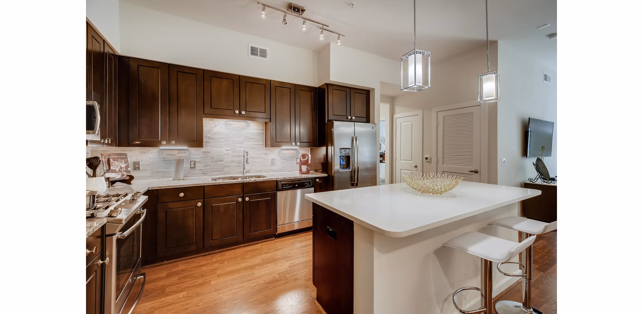 Modern kitchen with stainless steel appliances in The Caroline Apartments