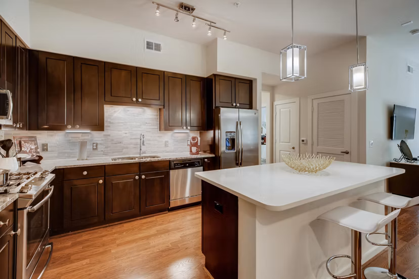Modern kitchen with stainless steel appliances in The Caroline Apartments