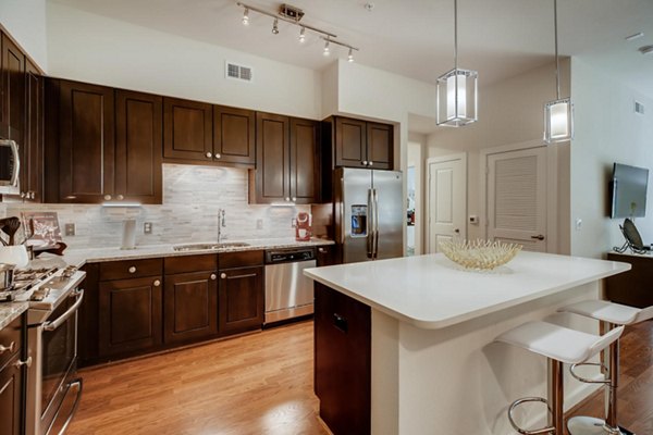Modern kitchen with stainless steel appliances in The Caroline Apartments