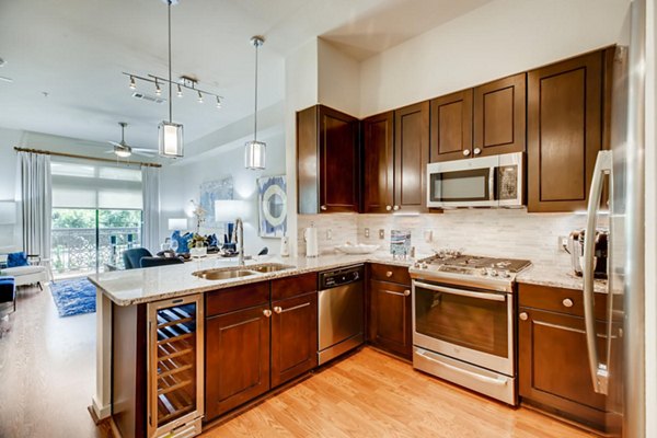 Modern kitchen featuring sleek countertops and stainless steel appliances at The Caroline Apartments