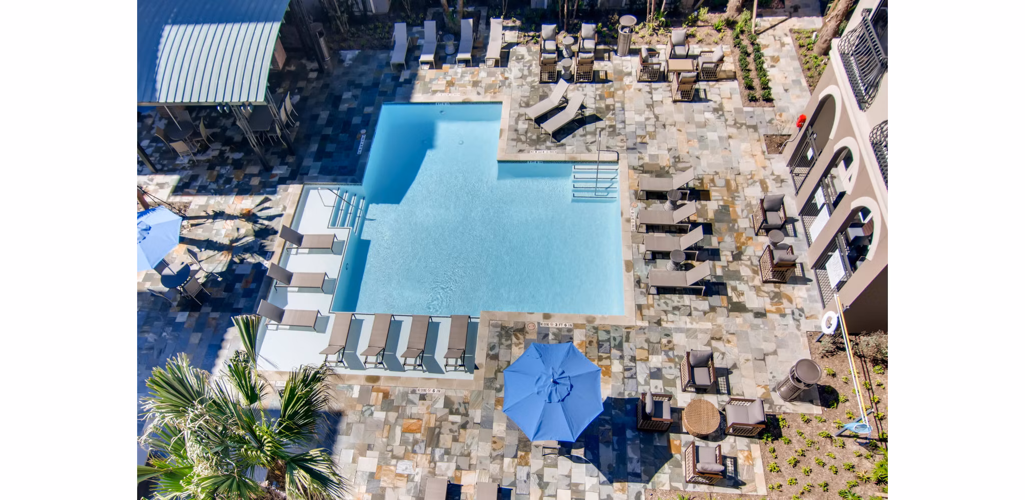 Luxurious poolside oasis at The Caroline Apartments, featuring sun loungers and a sparkling swimming pool for relaxation and leisure