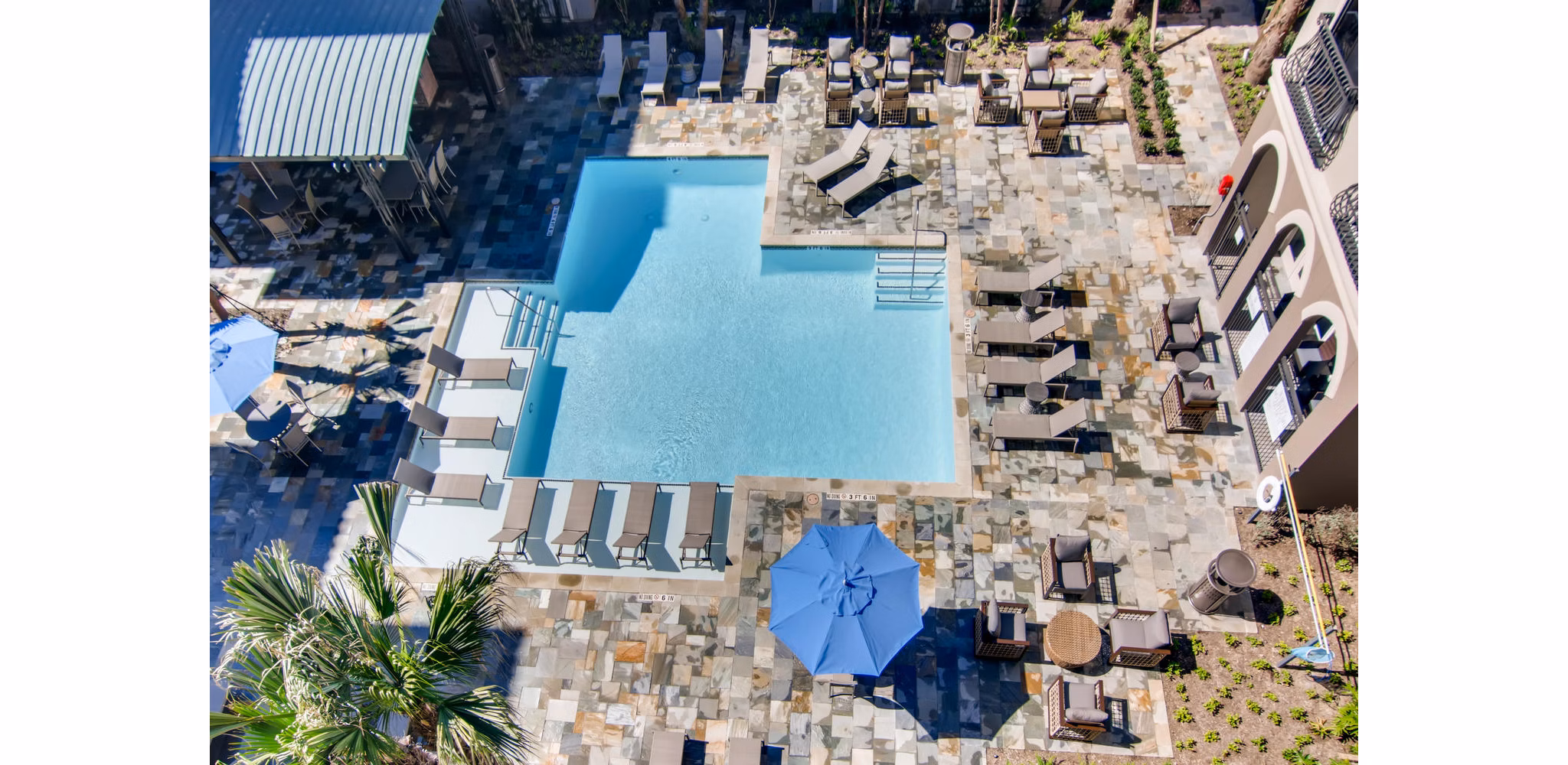 Luxurious poolside oasis at The Caroline Apartments, featuring sun loungers and a sparkling swimming pool for relaxation and leisure