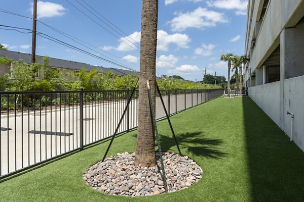 Spacious dog park with agility equipment at The Caroline Apartments, offering a pet-friendly environment for residents and their furry friends