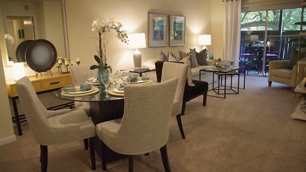 Modern living and dining room with round table, upholstered chairs, and stylish decor in luxury apartment