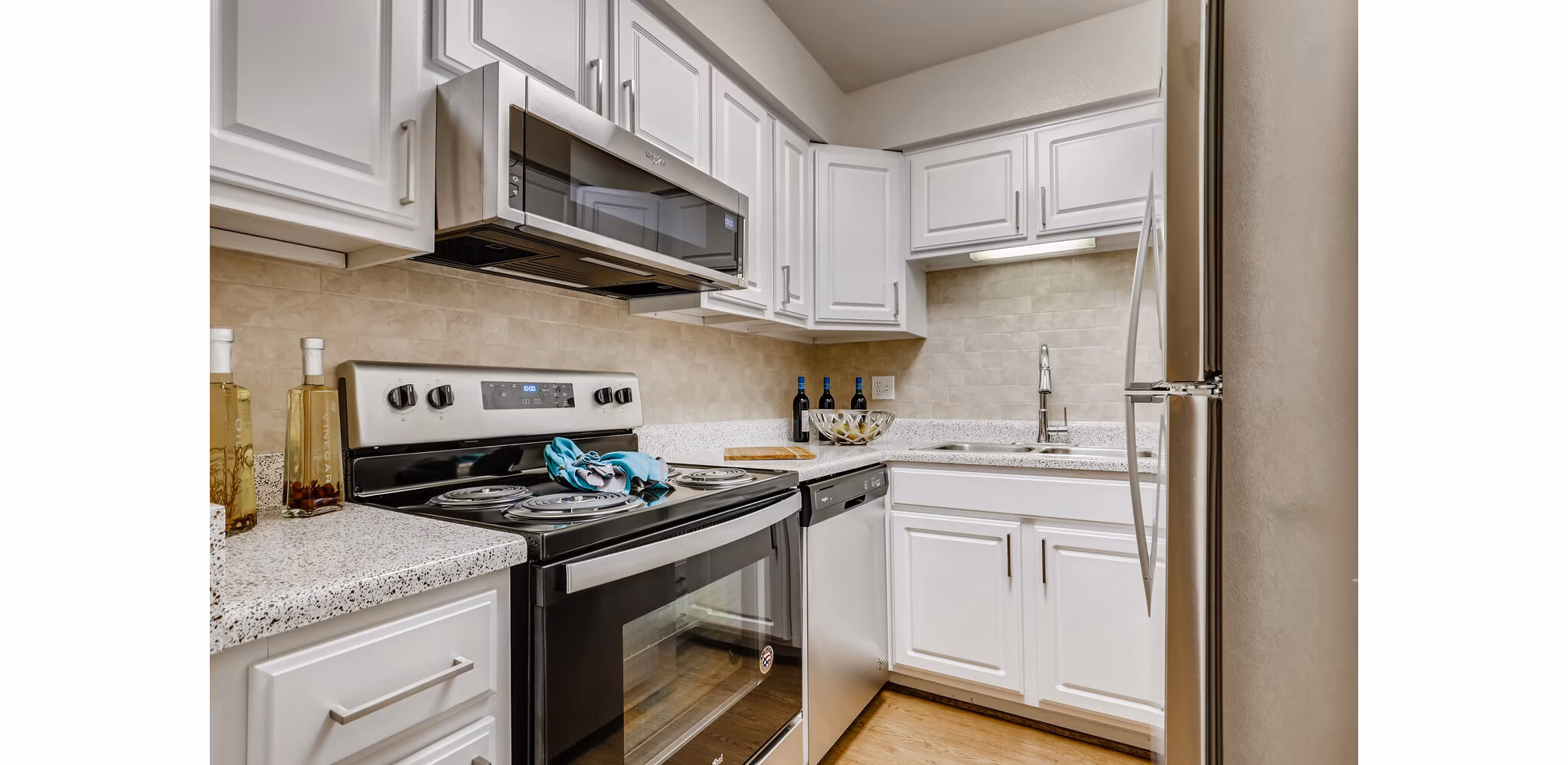 Kitchen featuring modern stainless steel appliances in The Creole on Yorktown Apartments