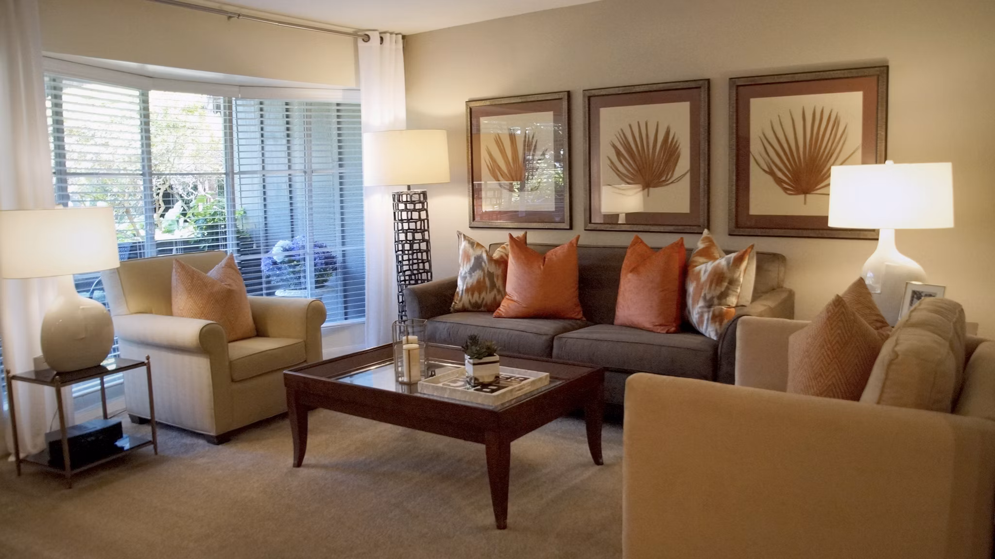 Spacious living room featuring stylish sofa, armchairs, and vibrant wall art in luxury apartment