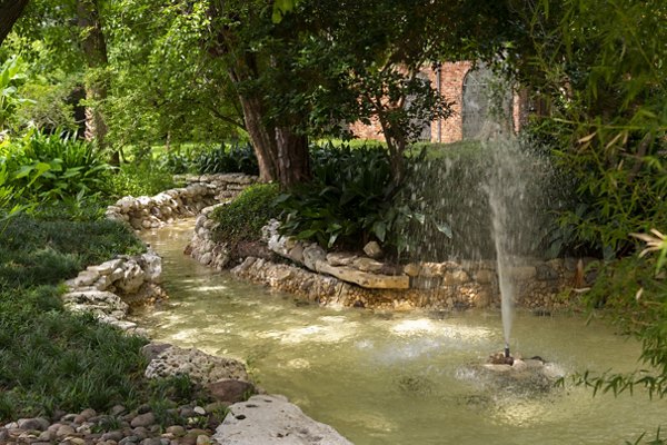 Courtyard featuring lush landscaping and seating areas at The Creole on Yorktown Apartments