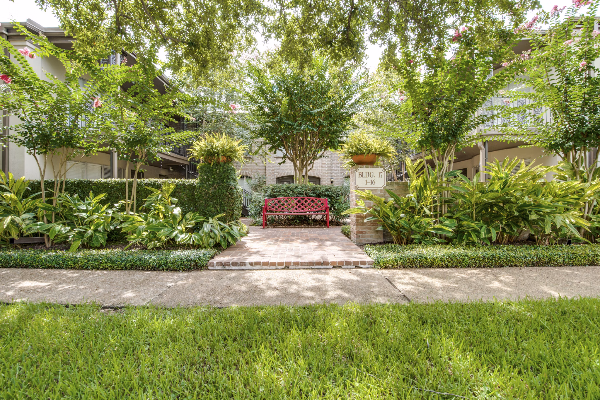 Courtyard with lush gardens and seating areas at The Creole on Yorktown Apartments