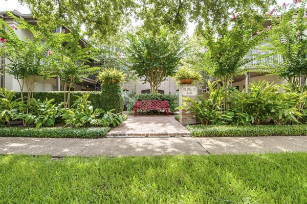 Courtyard with lush gardens and seating areas at The Creole on Yorktown Apartments