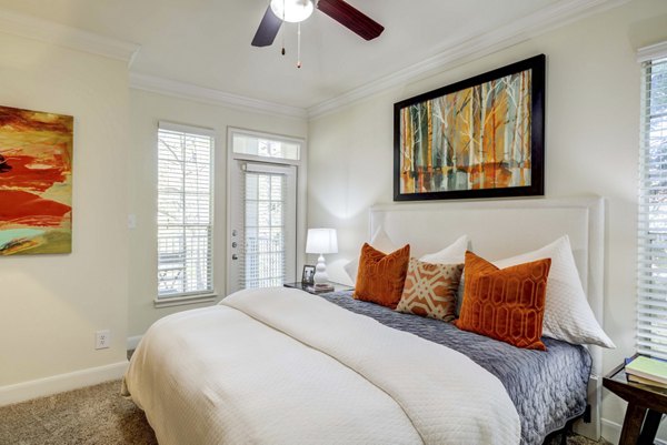 Cozy bedroom with elegant decor and ample natural light at The Park at Armand Bayou Apartments