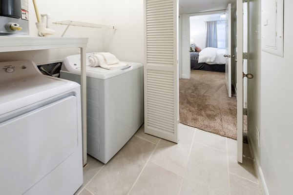 Laundry room with modern appliances at The Park on Memorial Apartments, featuring energy-efficient machines and ample folding space