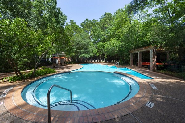 Resort-style pool area at The Park on Memorial Apartments, surrounded by lush landscaping and luxury lounging options