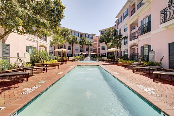 Modern pool area at Park at River Oaks Apartments with luxury seating and lush greenery