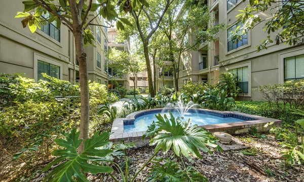 Relaxing courtyard with lush landscaping at The Post Oak at Woodway Apartments