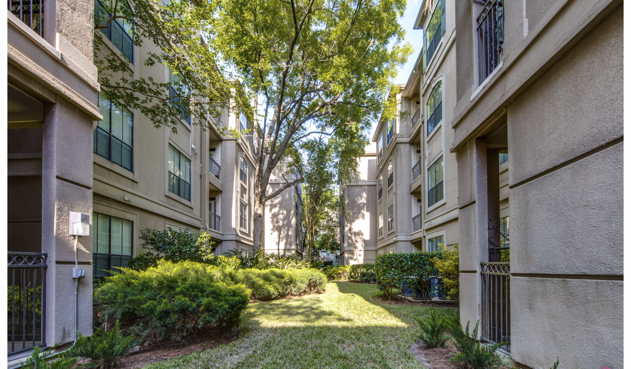 Courtyard featuring lush gardens and outdoor seating at The Post Oak at Woodway luxury apartments