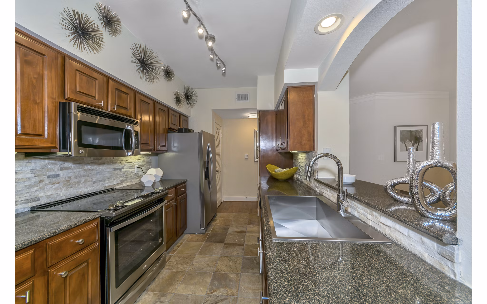 Modern kitchen with stainless steel appliances at Renaissance at Preston Hollow Apartments