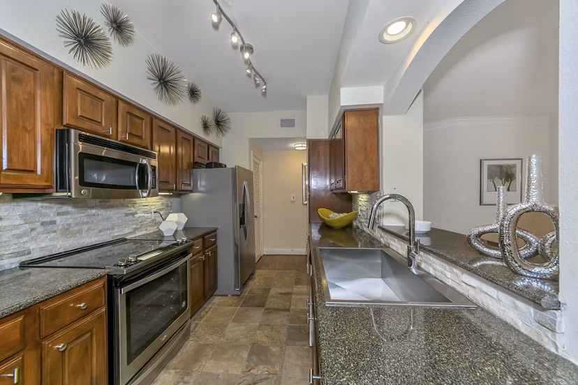 Modern kitchen with stainless steel appliances at Renaissance at Preston Hollow Apartments