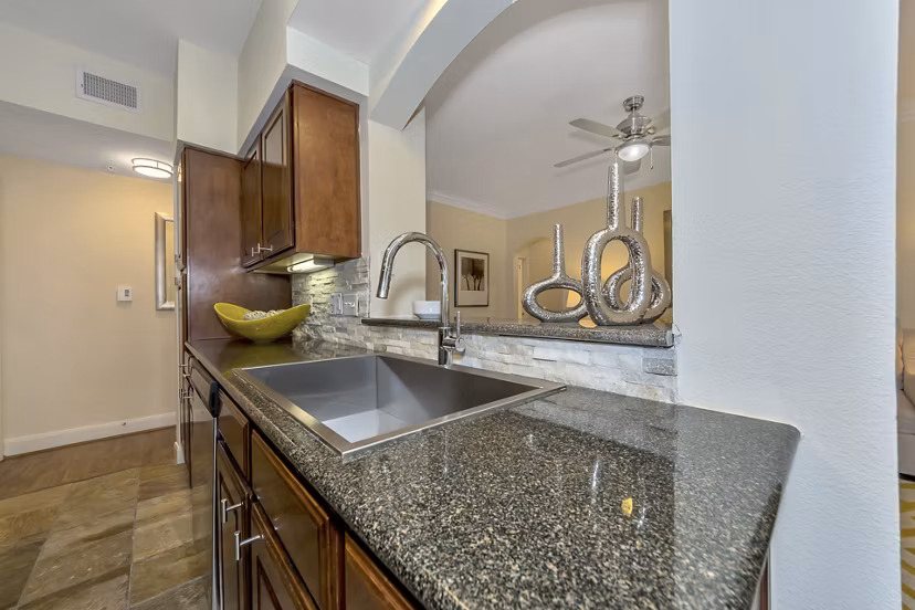 Modern kitchen with stainless steel appliances at Renaissance at Preston Hollow Apartments