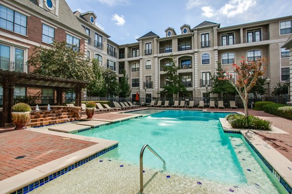 Luxurious outdoor pool at Renaissance at Preston Hollow Apartments with sleek lounge seating and palm trees