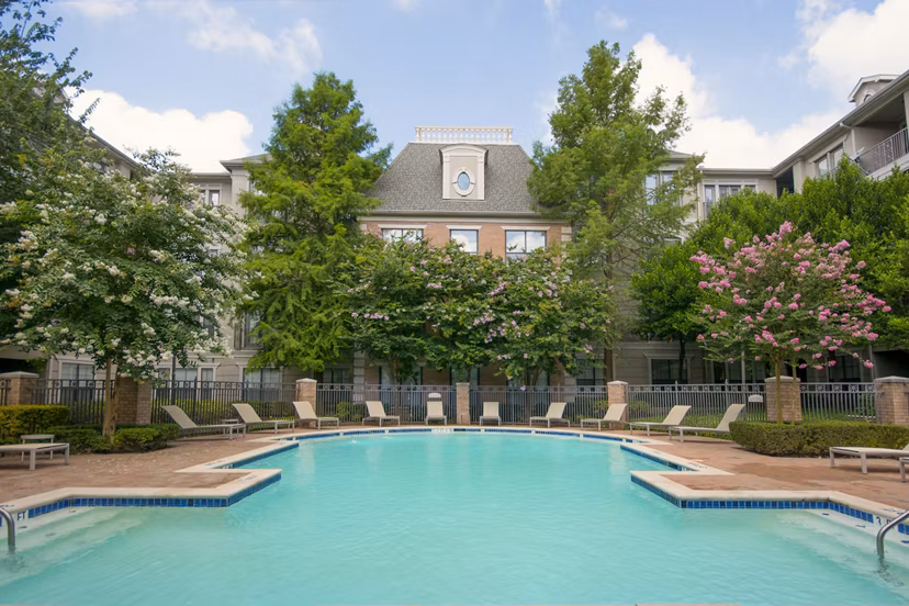 Outdoor swimming pool with lounge chairs at Renaissance at Preston Hollow Apartments