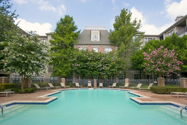 Outdoor swimming pool with lounge chairs at Renaissance at Preston Hollow Apartments